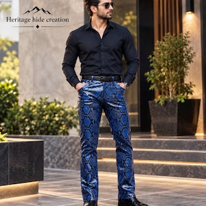 May include: A long-sleeve black button-down shirt paired with blue and black snakeskin-patterned trousers. The trousers feature a straight-leg cut, a black belt, and a glossy finish. The text "Heritage hide creation" appears in the upper left corner.