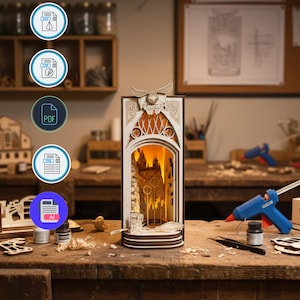 Könnte beinhalten: Ein detailliertes, geschichtetes Holzkunstwerk, das eine Schlossszene darstellt und von innen beleuchtet wird. Das Kunstwerk weist komplizierte Ausschnittmuster auf und steht auf einer Holzwerkbank mit Bastelbedarf. Das Stück ist wahrscheinlich ein DIY- oder Bastelprojekt.