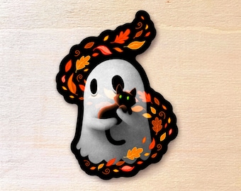Può includere: Un fantasma bianco con un gatto nero tra le braccia, circondato da foglie arancioni, rosse e gialle. Il fantasma ha un'espressione amichevole e sorride.