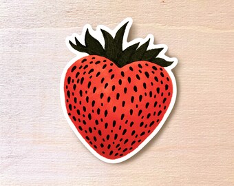 Può includere: Un adesivo a forma di cuore di fragola rosso e nero con un gambo e foglie verdi.