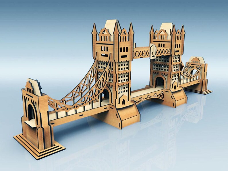 May include: A wooden model of the Tower Bridge, featuring intricate cut-out details. The model is made of light brown wood and has a detailed design of the iconic London landmark. The bridge spans across a light blue surface.