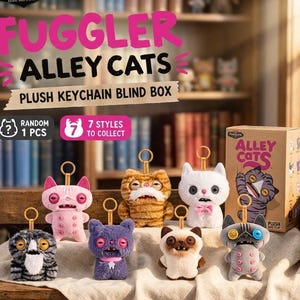 May include: Fuggler Alley Cats plush keychain blind box featuring seven styles to collect. The set includes various small, fuzzy cat-like creatures with button eyes, teeth, and gold-coloured metal keychains attached to their heads, displayed with a box.