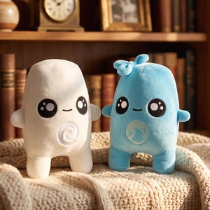 May include: Two plush toys with rounded bodies and short limbs. The left toy is white with a spiral symbol on its belly. The right toy is light blue with a bow on its head and a water drop symbol on its belly. Both have large black eyes.