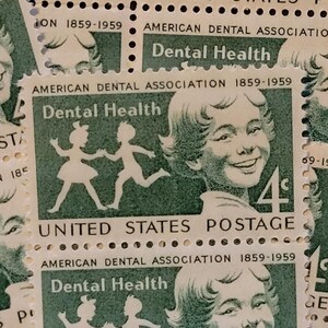 May include: Vintage United States postage stamps featuring a green and white design. The stamps commemorate the American Dental Association from 1859-1959, with the words "Dental Health" and a smiling child. Each stamp is valued at 4 cents.