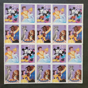 May include: A sheet of postage stamps featuring Disney characters. The stamps depict Cinderella and Prince Charming, Mickey and Minnie Mouse, Belle and the Beast, and Lady and the Tramp. Each stamp has the text "39 USA".