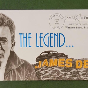 May include: An envelope featuring a portrait of James Dean, the text "THE LEGEND..." in blue, and the name "JAMES DEAN" in yellow. Includes a stamp with Dean's image and the WB logo. The envelope commemorates the First Day of Issue at Warner Bros. Studios.