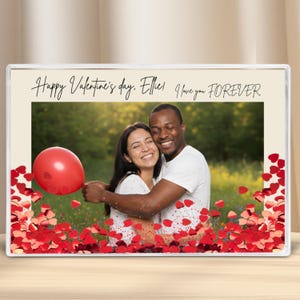 Peut inclure: Une photo encadrée d'un couple s'embrassant, avec un ballon rouge et des confettis en forme de cœur. Le texte dit "Happy Valentine's day, Ellie! I love you FOREVER."