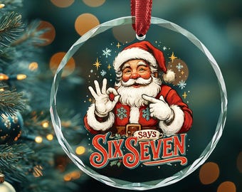 May include: A clear glass Christmas ornament with a red ribbon. The ornament features a cartoon Santa Claus in a red suit and hat, with the text "Six Seven". The background includes a Christmas tree with ornaments.