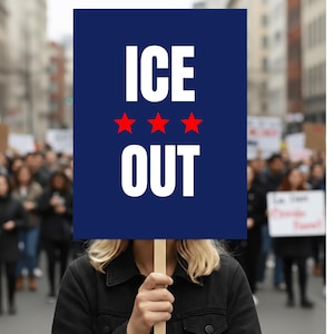 May include: A person holding a blue sign with the words "ICE OUT" in white, and three red stars. The sign is held in front of a crowd of people.