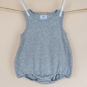 May include: A gray sleeveless baby onesie with a small white label that says "CCC Blanks".