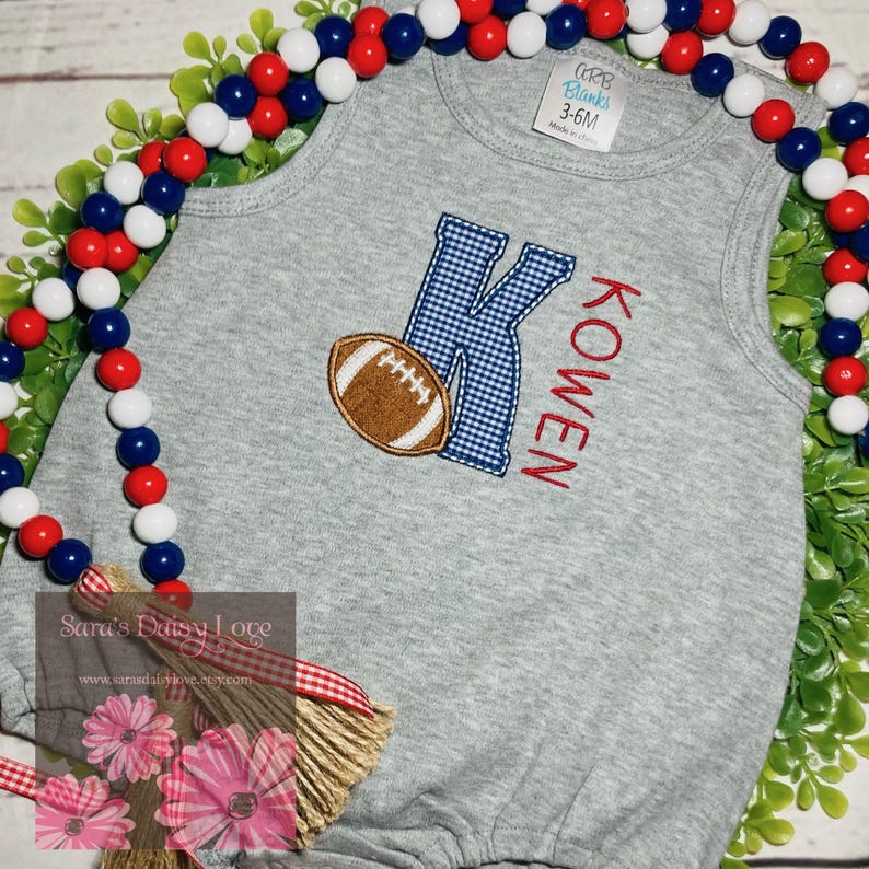 May include: Gray sleeveless onesie with a blue and white checkered letter K, a brown football, and the name "KOWEN" embroidered in red.