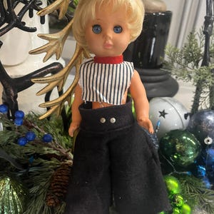 Vintage plastdocka från 1970-talet med blont hår och randig outfit