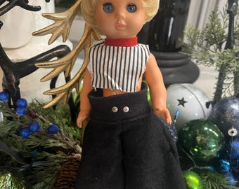 Muñeca de moda de plástico vintage de los años 70 con cabello rubio y traje a rayas.