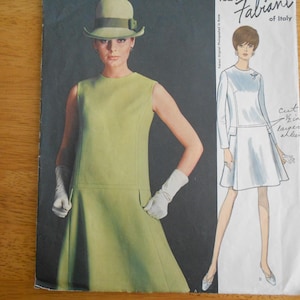 May include: Vintage sewing pattern featuring a woman in a sleeveless lime green dress, white gloves, and a matching hat. The pattern cover also shows a drawing of a white dress with long sleeves. The brand name "Fabiani of Italy" is visible.