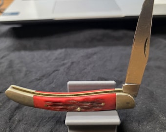 Canivete dobrável com cabo texturizado vermelho e espiga, marcado UC-5011.