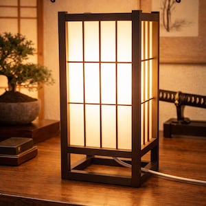 May include: A rectangular Japanese lamp with a dark brown frame and a grid design. The lamp emits a warm, glowing light. The text "Japanese Lamp" is displayed at the top of the image.