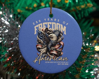 May include: A round, blue ceramic ornament with a gold string for hanging. The ornament features an eagle with red, white, and blue accents, the words "250 Years of Freedom" and "American Semicentennial July 4th 2026".