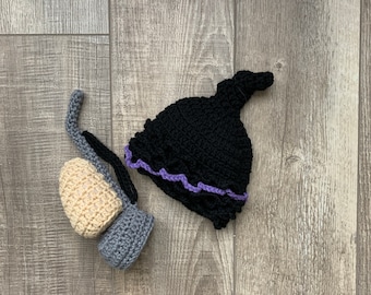 May include: A black crocheted hat with a purple trim and a gray and beige crocheted boot.