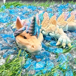 May include: A set of three ceramic mugs with a speckled, matte finish. Each mug features a different color: light blue, cream, and gray. The mugs have a simple, modern design with a rounded shape and a comfortable handle.