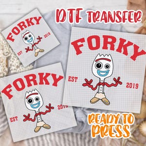 May include: DTF transfer sheets featuring the character Forky from Toy Story. The design includes Forky's face and arms, the word "Forky" in red, and the text "EST 2019". The phrase "Ready to Press" is also visible.