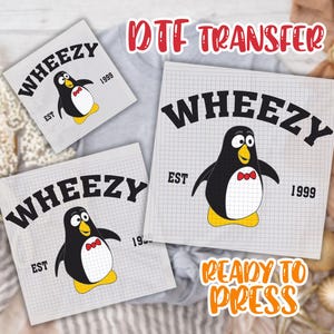 May include: DTF transfer sheets featuring a cartoon penguin design. The penguin is black and white with a red bow tie and yellow feet. The word "WHEEZY" arches above the penguin, with "EST 1999" below. The text "READY TO PRESS" is also visible.