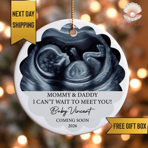 May include: A white ceramic ornament with a scalloped edge, featuring a grayscale ultrasound image of a baby. Text includes "Mommy & Daddy, I can't wait to meet you! Baby Vincent, Coming Soon 2026."