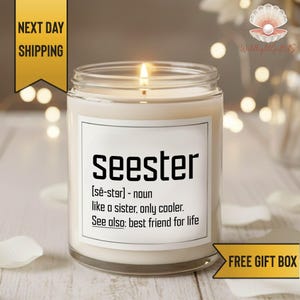 May include: A lit candle in a glass jar with a white label. The label reads "seester" with a definition. The candle is on a wooden surface. The image also includes text that says "Next Day Shipping" and "Free Gift Box".