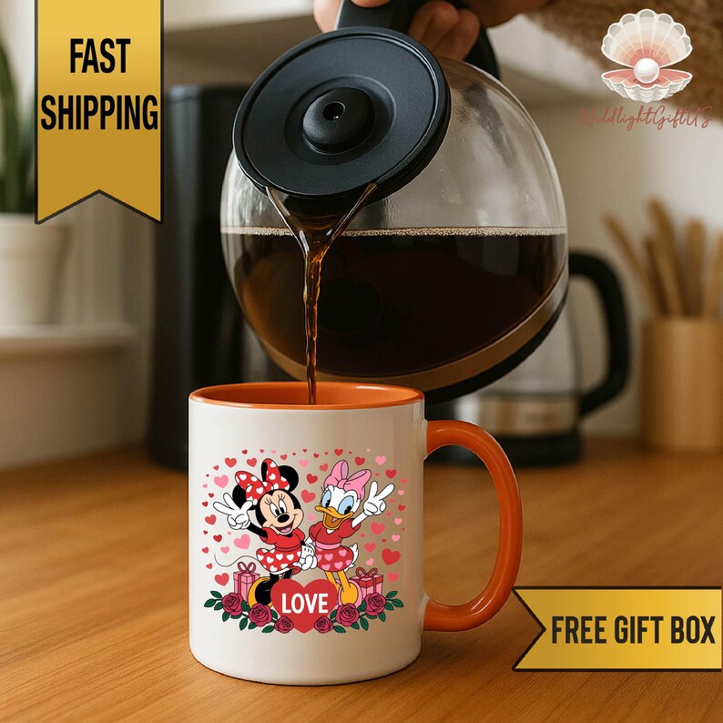 A coffee mug with a Minnie Mouse and Donald Duck design, along with the word "LOVE" written on it, is being filled with coffee from a coffee pot.