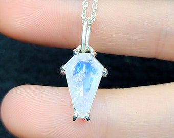 Op de afbeelding: Een zilveren ketting met een hanger van maansteen in de vorm van een kist.
