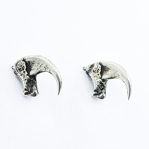 Peut inclure: Une paire de boucles d'oreilles en argent en forme de griffes. Les boucles d'oreilles sont détaillées et ont une finition texturée.