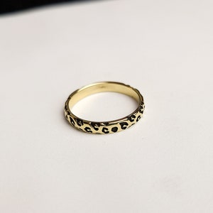 May include: A gold ring with a leopard print design.
