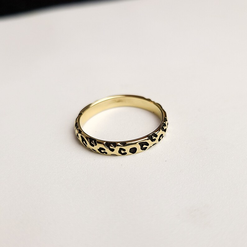 May include: A gold ring with a leopard print design.