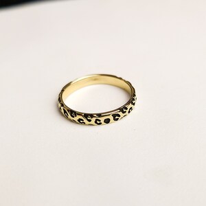 May include: A gold ring with a leopard print design.