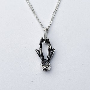 Puede incluir: Un collar de plata con un colgante detallado de la cabeza de un conejo. El conejo tiene orejas grandes y una nariz peque&ntilde;a.