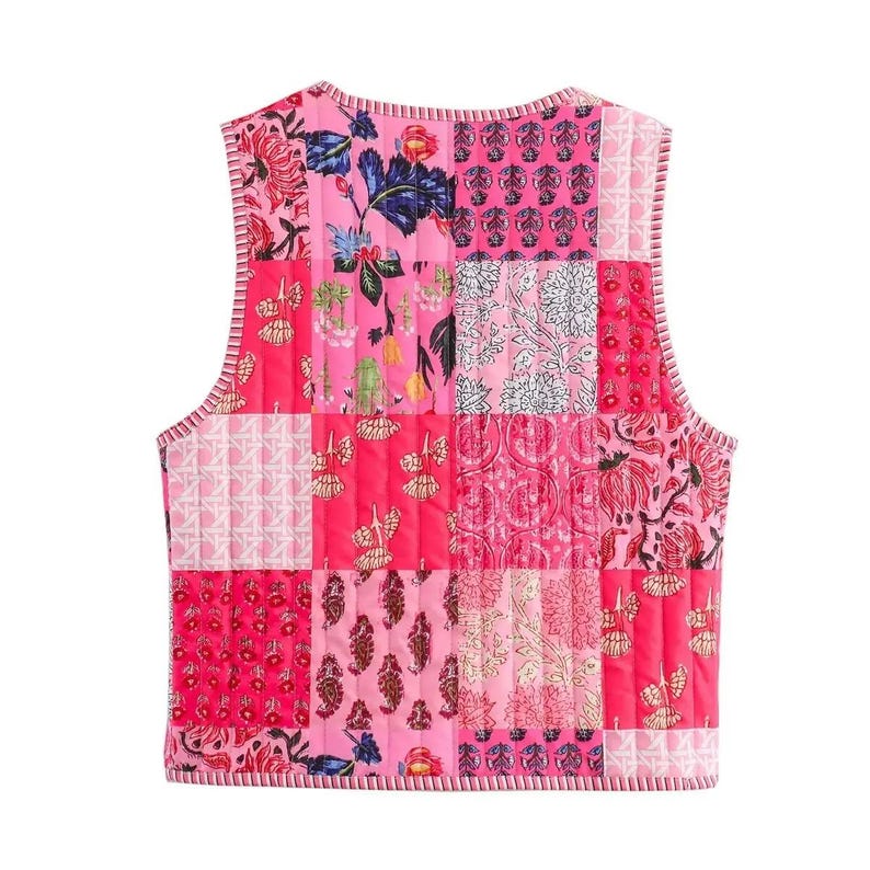 May include: A sleeveless, quilted vest featuring a patchwork design of various pink floral patterns. The vest has a round neckline and a vertical quilted stitch. The edges are trimmed with a pink and white striped fabric.