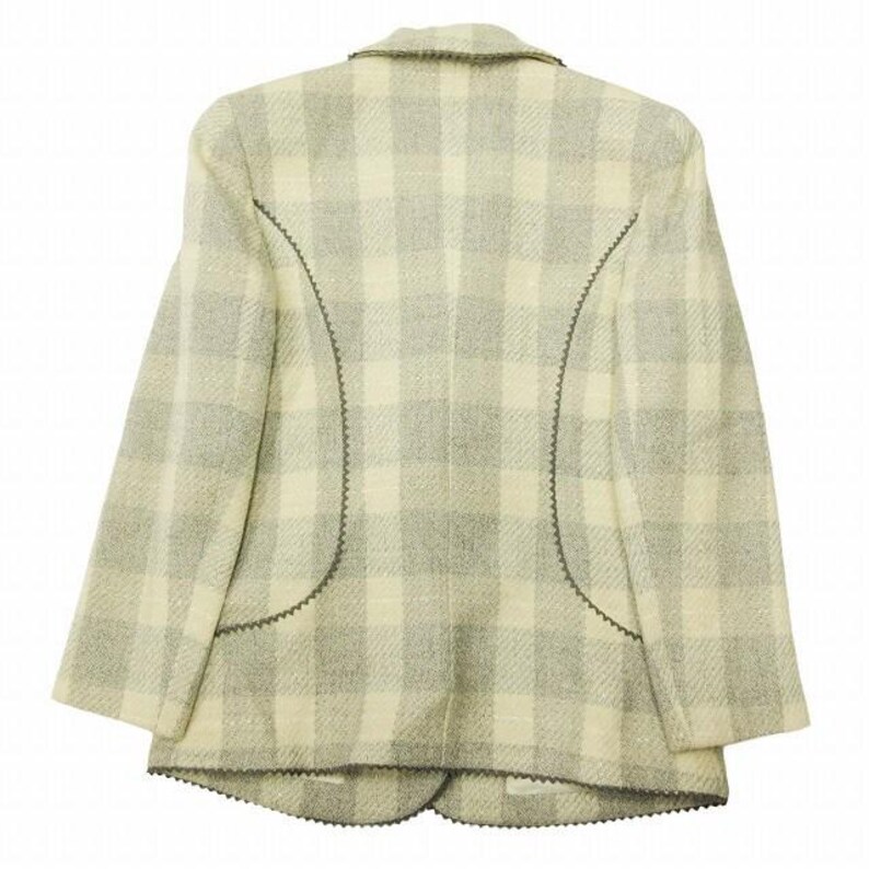 May include: A light-colored blazer with a plaid pattern in shades of cream and gray. The blazer has a notched collar and decorative stitching along the seams. The back view of the jacket is shown.