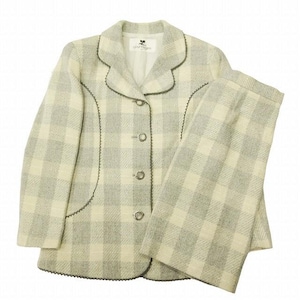 May include: A two-piece suit in a light gray and cream plaid pattern. The jacket has a notched collar, three silver buttons, and dark gray trim. The matching pants are straight-legged. The suit is made of a textured fabric.