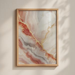 Può includere: Un'opera d'arte murale rettangolare con un motivo astratto di pietra agata nei toni del crema, bianco e rosso terracotta, accentuato da sottili venature dorate irregolari. L'opera è racchiusa in una semplice cornice in legno chiaro.