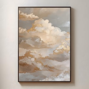 May include: Framed abstract cloudscape print. The artwork uses beige, gold, and grey tones to depict fluffy clouds with gold accents. The painting is set in a black frame, creating a soft, ethereal effect and evoking a sense of tranquility.