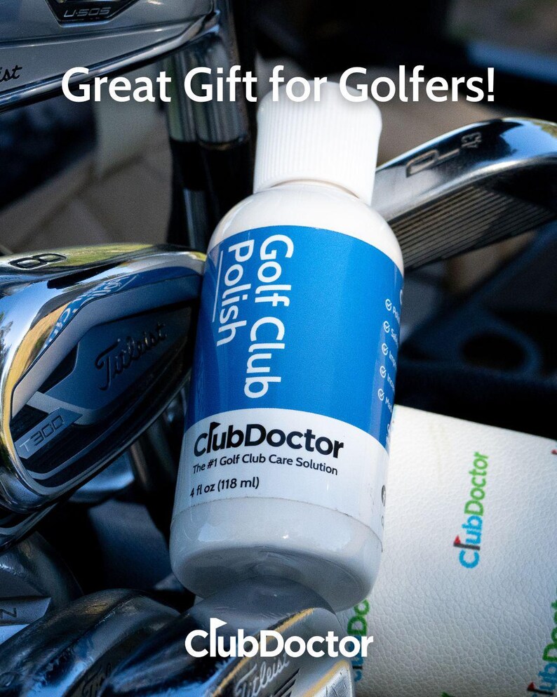 以下が含まれることがあります： 青いラベルが付いたClubDoctorゴルフ用クラブポリッシュの白いプラスチックボトル。Great Gift for Golfers!、ClubDoctor、The #1 Golf Club Care Solution、118mlという文字が記載されており、複数の金属製ゴルフクラブの間に置かれています。