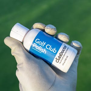 以下が含まれることがあります： 青いラベルが付いたClubDoctorゴルフ用クラブポリッシュの白いプラスチックボトル。ラベルには「Golf Club Polish」、「clubDoctor」、「The #1 Golf Club Care Solution」、「118 ml」という文字が記載されています。ボトルには白いスクリューキャップが付いています。