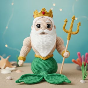 May include: A crocheted doll of a merman king with a white beard, gold crown, and a green mermaid tail. The doll holds a gold trident. The background is a light blue with a sandy surface.