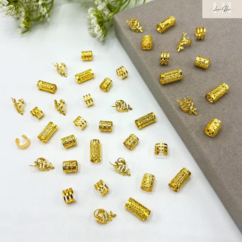 以下が含まれることがあります： 金色のジュエリーパーツのコレクション。ビーズ、チューブ、装飾的なアクセントが含まれています。これらのパーツは、形や大きさが異なり、表面はテクスチャード加工と滑らかさがあります。一部には複雑な葉や花の模様があり、その他はシンプルな円柱です。