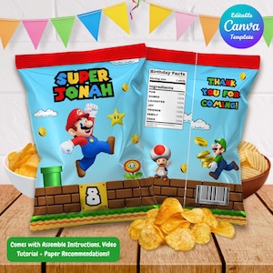 Puede incluir: Dos bolsas de patatas fritas azules con la parte superior roja, con personajes de Super Mario y el texto "SUPER JONAH". Una bolsa dice "¡GRACIAS POR VENIR!". Las bolsas están sobre una mesa de madera con patatas fritas y cuencos.