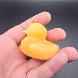 May include: A small, yellow duck figurine. The duck is a solid color with a smooth texture. The duck is a classic toy or decorative item, often associated with bath time or children's play.