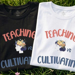 Puede incluir: Dos camisetas, una negra y otra blanca, con la frase "TEACHING is CULTIVATING" en coral y azul. Cada camiseta presenta un perfil de mujer adornado con una corona floral.