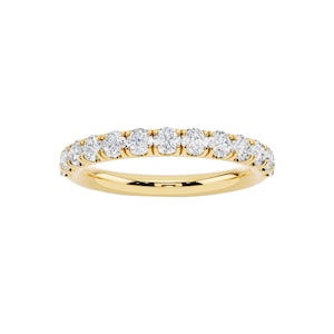 Könnte beinhalten: Ein goldener Bandring mit einer Reihe runder, klarer Edelsteine. Der Ring ist vor einem weißen Hintergrund platziert, was das Funkeln der Edelsteine und den Glanz des Goldes hervorhebt.
