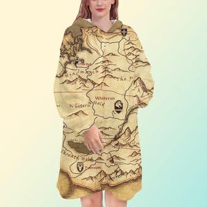 May include: A hooded sweatshirt with a map design in tan and brown. The map includes place names such as Whiterun and Falkreath. The sweatshirt has a relaxed fit and a hood.