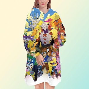 Pode incluir: Um cobertor com capuz com um gráfico colorido de personagens de anime. O design inclui uma variedade de figuras em tons de azul, amarelo, laranja e roxo. O cobertor tem um interior branco e um capuz azul.