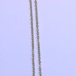 May include: Gold-toned necklace with a pendant featuring a central oval design with an angel figure, surrounded by clear crystals. The chain is delicate and hangs against a light background.